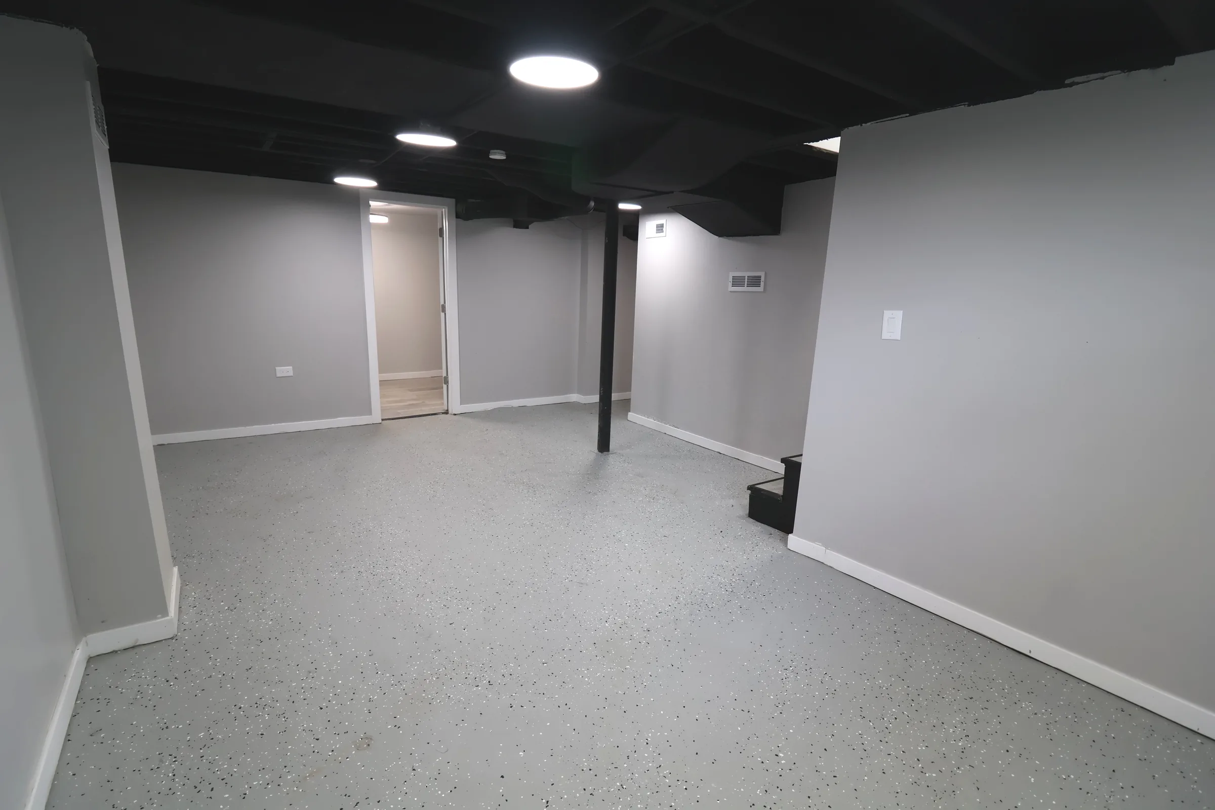 Finished basement with painted walls and coated floor