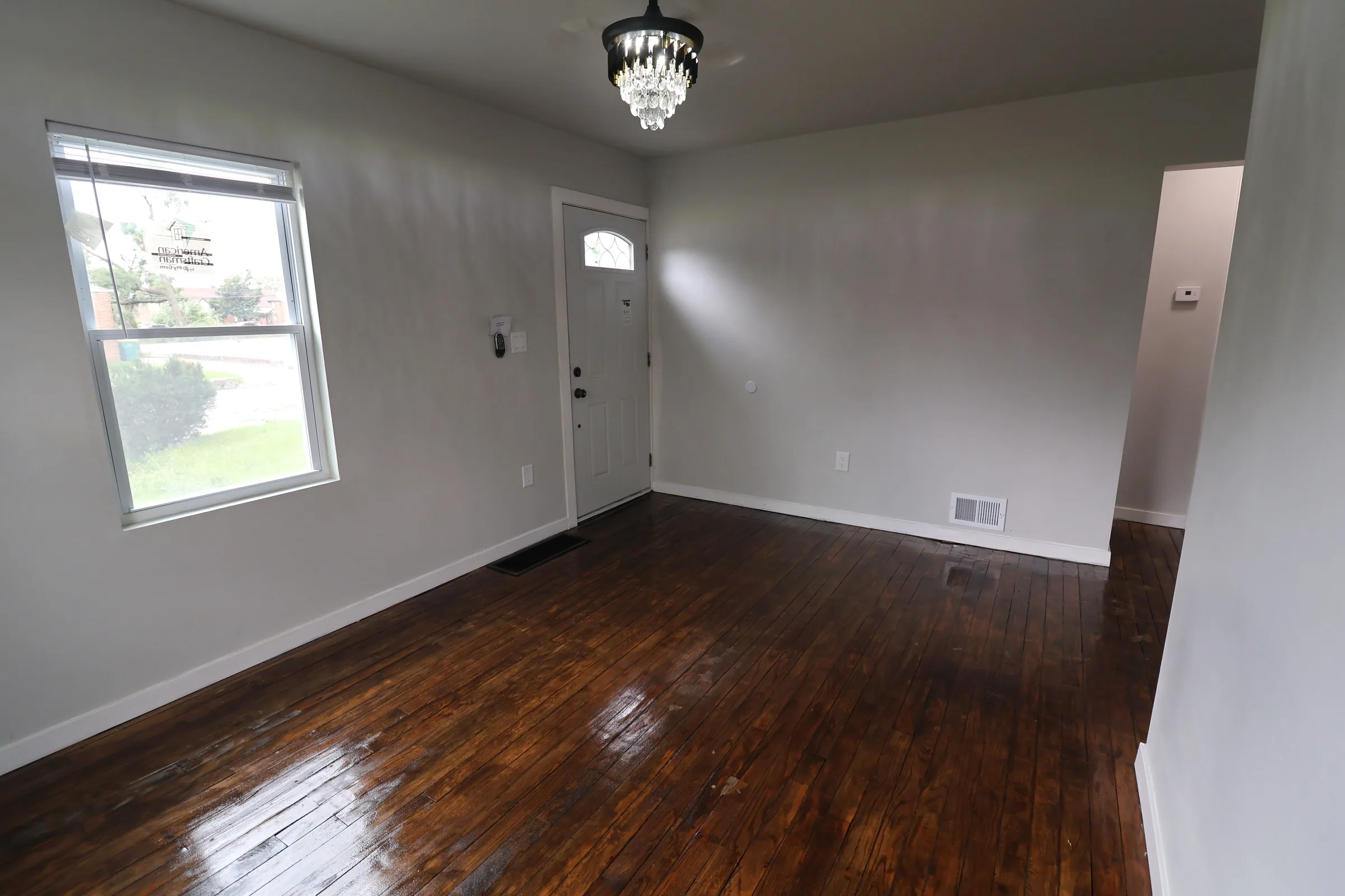 Finished living room with chandelier and hardwood floors
